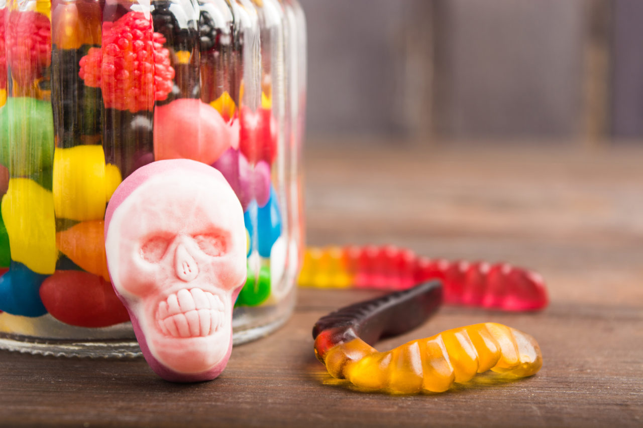 Closeup sweet skull wit sweet worms over wooden background with copy space